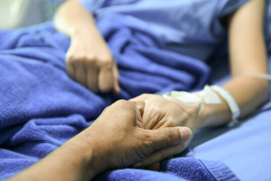 A zoomed in photo of an elderly person holding hands.