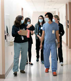Healthcare workers walking in a hallway while conversing